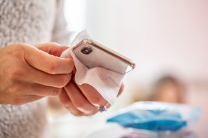Persona che pulisce uno smartphone con una salvietta