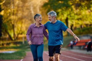 Coppia di persone mature che cammina facendo attività fisica per mantenere la salute del cervello e prevenire il declino cognitivo