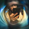 Persona che guarda lo smartphone con effetto visivo distorto, rappresentazione della dipendenza da social media e perdita di controllo