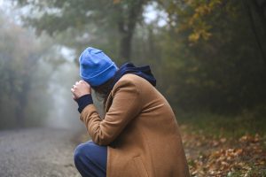 Persona seduta all’aperto con postura chiusa e testa tra le mani, rappresentazione del disagio emotivo legato ai disturbi d’ansia.