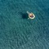 Vista dall'alto di una persona che galleggia in mare; il nuoto apporta benefici cardiovascolari e muscolari ma ha effetti limitati sul rafforzamento delle ossa