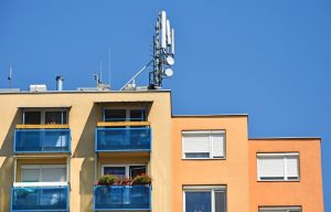 Antenna 5G installata sul tetto di un edificio residenziale in area urbana, esempio di infrastruttura per la telefonia mobile e dei campi elettromagnetici discussi in relazione alla salute.