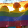 Persone della comunità LGBTQ+ sotto una bandiera arcobaleno durante il Pride, contesto delle disuguaglianze sanitarie e dell’accesso ai servizi di prevenzione.