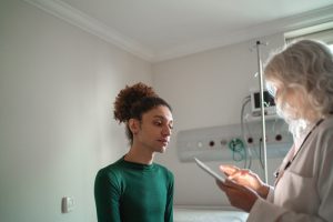 Persona transgender durante una visita medica in ospedale, esempio delle sfide nell’accesso alle cure e nel rapporto con il personale sanitario.