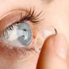 Persona che inserisce una lente a contatto nell'occhio, corretta applicazione delle lenti prima dell'uso.