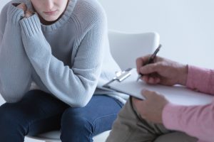 Adolescente seduta durante un colloquio di supporto psicologico, immagine che rappresenta il riconoscimento precoce del disagio emotivo e dei comportamenti autolesionistici in età evolutiva.