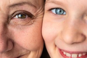 Primo piano del volto di una donna e di una bambina, a confronto per evidenziare le differenze tra pelle adulta e pelle infantile.