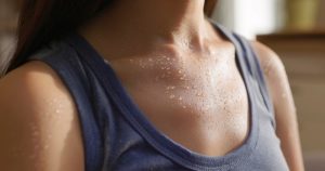 Primo piano di pelle coperta di gocce di sudore, che mostra il naturale processo di termoregolazione del corpo umano.