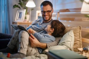 Padre e figlio trascorrono del tempo di qualità leggendo un libro.