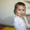 Bambina che usa il ciuccio e sorride.
