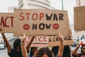 Manifestanti durante una protesta contro la guerra con cartelli per la pace