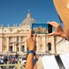 Turista fotografa la Basilica di San Pietro in piazza San Pietro, a Roma.