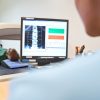 Paziente sottoposto a densitometria ossea mentre il risultato dell’esame viene visualizzato su un monitor
